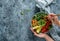 Hands holding healthy superbowl or Buddha bowl with salad, baked sweet potatoes, chickpeas, broccoli, hummus, avocado, sprouts on