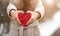 Hands are holding a heart with a printable plan on a blurred background. Valentine`s Day