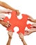 Hands holding jigsaw puzzle as teamwork concept