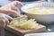 Hands holding a knife cutting some potatoes in a rustic kitchen. Empty copy space