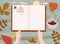 Hands holding an open Autumn Daily Diary notepad, list schedule, goals, to do, acorn, autumn leaves, coffe cup. Personal