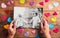 Hands holding picture of senior couple, colorful hearts. Studio