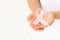 Hands holding pink ribbon curl on white isolated fabric with copy space. Breast cancer Awareness, male breast cancer disease,
