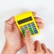 Hands holding a pocket digital calculator on white background