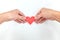 Hands holding a red heart shape in white background. Spread love, healthy heart, kindness concept.