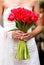 Hands holding red tulips wedding bouquet