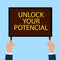 Hands Holding a Sign with the Word unlock your potential