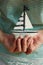 Hands holding small saiboat