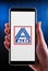 Hands holding smartphone displaying logo of Aldi