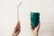 Hands holding stylish reusable eco coffee cup and steel straw on white wooden background. Zero waste. Green Cup from natural