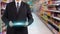 Hands holding tablet pc in supermarket in blurry