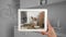 Hands holding tablet showing modern kitchen close-up. Total white draft of minimalist kitchen in the background, architecture inte
