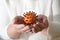 Hands are holding a tangerine with cloves, which looks like a coronavirus, but vitamins strengthen the immune system and cloves