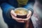 hands holding a warm bowl of pho on a cold day