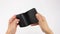 Hands holds black leather wallet, open it and search for money, purse is empty, inscription leather, white background