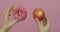 Hands holds donut and apple. Choice donut against apple. Healthy or junk food