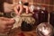 Hands of a housewife, chef confectioner tying bow with a rope around a burlap on a lid of a jar with freshly made cherry berry jam