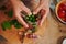 Hands of housewife stacks spices, herbs and chili peppers into a sterilized glass jar while canning in the home kitchen.