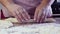 The hands of a Jewish woman form blanks of dough for the festive Challah on the table