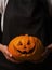 Hands keep pumpkin for halloween close up. Smiling halloween pumpkin holiday decoration