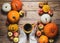 Hands keeping cup of coffee and pumpkins on wood background