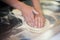 Hands knead the dough for pizza making