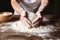 hands kneading dough on floured wooden table