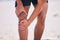 Hands, knee pain and athlete at beach, accident and fitness exercise in sport workout outdoor. Legs, injury and