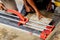 Hands of laborer using cutting tile machine at construction site