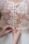 Hands lacing corset of wedding gown