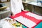 Hands of lady tailor working in her studio, tools and fabric samples on the sewing table