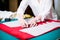 Hands of lady tailor working in her studio, tools and fabric samples on the sewing table