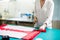 Hands of lady tailor working in her studio, tools and fabric samples on the sewing table