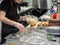 Hands in latex gloves lay out the ingredients for Japanese rolls in plastic disposable containers. Japanese food