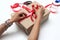 Hands of a Latina woman wraps a gift with paper and a red ribbon makes a bow with scissors and adhesive tape to give as a gift and