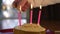 Hands lighting candles on a birthday cake