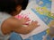 Hands of a little baby with red color pressing down on white paper - baby handprint / fingerprint painting