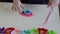 Hands of little girl 3-5 years old playing pink play dough with plastic molds