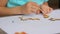 Hands of little girl painting wooden blanks