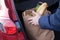 Hands loading a shopping bag in car trunk