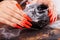 Hands with long artificial manicured nails colored with orange nail polish and Halloween decorations