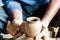 Hands of making clay pot on the pottery wheel ,select focus, close-up.