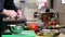 Hands of male chef cook peeling onion in kitchen