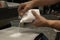 Hands of male chef dumping the ingredients of a recipe on an electronic scale