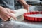 Hands of male chief cook making pie in baking pan