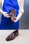 Hands of Male Shoes Cleaner with Cloth For Brown Leather Penny Loafers Footwear While Cleaning in Workshop