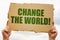 In the hands of a man is a cardboard sign with the inscription - Change The World