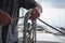 Hands of a man coiling up a rope, the sheet on a sailboat