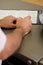 Hands of a man on a desktop beside a clipboard