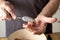 Hands of a man are forming balls of raw minced meat and other ingredients with a spoon to make meatballs